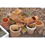 A COLLECTION OF MODERN TERRACOTTA PLANT POTS AND A VINTAGE CHIMNEY POT the largest pot being 47cm