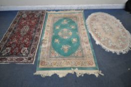 A GREEN GROUND CHINESE WOOLEN RUG,, with multi-strap border, 194cm x 123cm, an oval rug, along