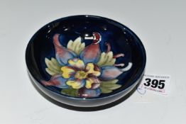 A MOORCROFT POTTERY SMALL FOOTED BOWL, decorated with Columbine on a blue ground, impressed and