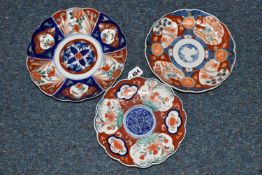 THREE LATE 19TH CENTURY JAPANESE IMARI PLATES, all with wavy rims, varying designs with flora and