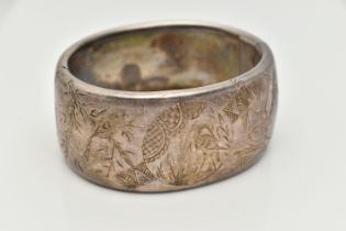 A WHITE METAL HINGED BANGLE, wide bangle engraved with an oriental design, fitted with a push