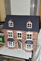 A MODERN THREE STOREY DOLLS HOUSE OF LATE VICTORIAN STYLE, with papered red brick effect exterior,