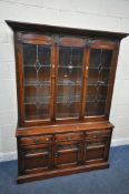 A 20TH CENTURY OLD CHARM OAK BOOKCASE, the top with double lead glazed doors, enclosing three