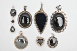 SEVEN SILVER AND WHITE METAL PENDANTS, most set with onyx, also a circular hematite pendant, a heart