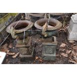 A PAIR OF EARLY 20th CENTURY CAST IRON URNS ON STANDS with fluted baluster bowl on a square foot and