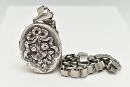 A WHITE METAL OVAL LOCKET AND BOOK CHAIN, the locket decorated with a floral and bow pattern,