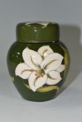 A MOORCROFT POTTERY GINGER JAR IN COVER DECORATED WITH WHITE LILIES ON A GREEN GROUND, faintly