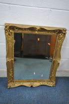 A RECTANGULAR GILT WOOD FRAMED WALL MIRROR, with scrolled and foliate detail, 89cm x 72cm (condition