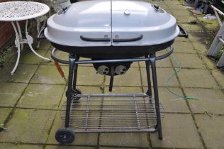 A MODERN COAL BARBECUE with dual enamel domed lids, temperature gauge, stand with undershelf width