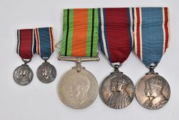 THREE MEDALS AND TWO MINIATURE MEDALS, to include a WWII defense medal, and two 'George V and