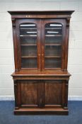 A 19TH CENTURY MAHOGANY BOOKCASE, fitted with two glazed doors, that are enclosing four adjustable