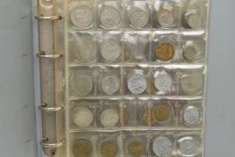 A SMALL COIN ALBUM CONTAINING WORLD COINS TO INCLUDE SOME SILVER CONTENT COINAGE