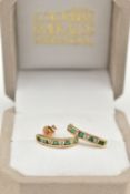 A PAIR OF EMERALD AND DIAMOND EARRINGS, each designed as half hoops channel set with four