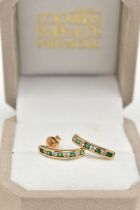 A PAIR OF EMERALD AND DIAMOND EARRINGS, each designed as half hoops channel set with four