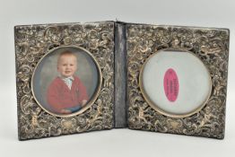 A DOUBLE PHOTO FRAME, white metal lined frame, with embossed foliate pattern with cherubs, folding