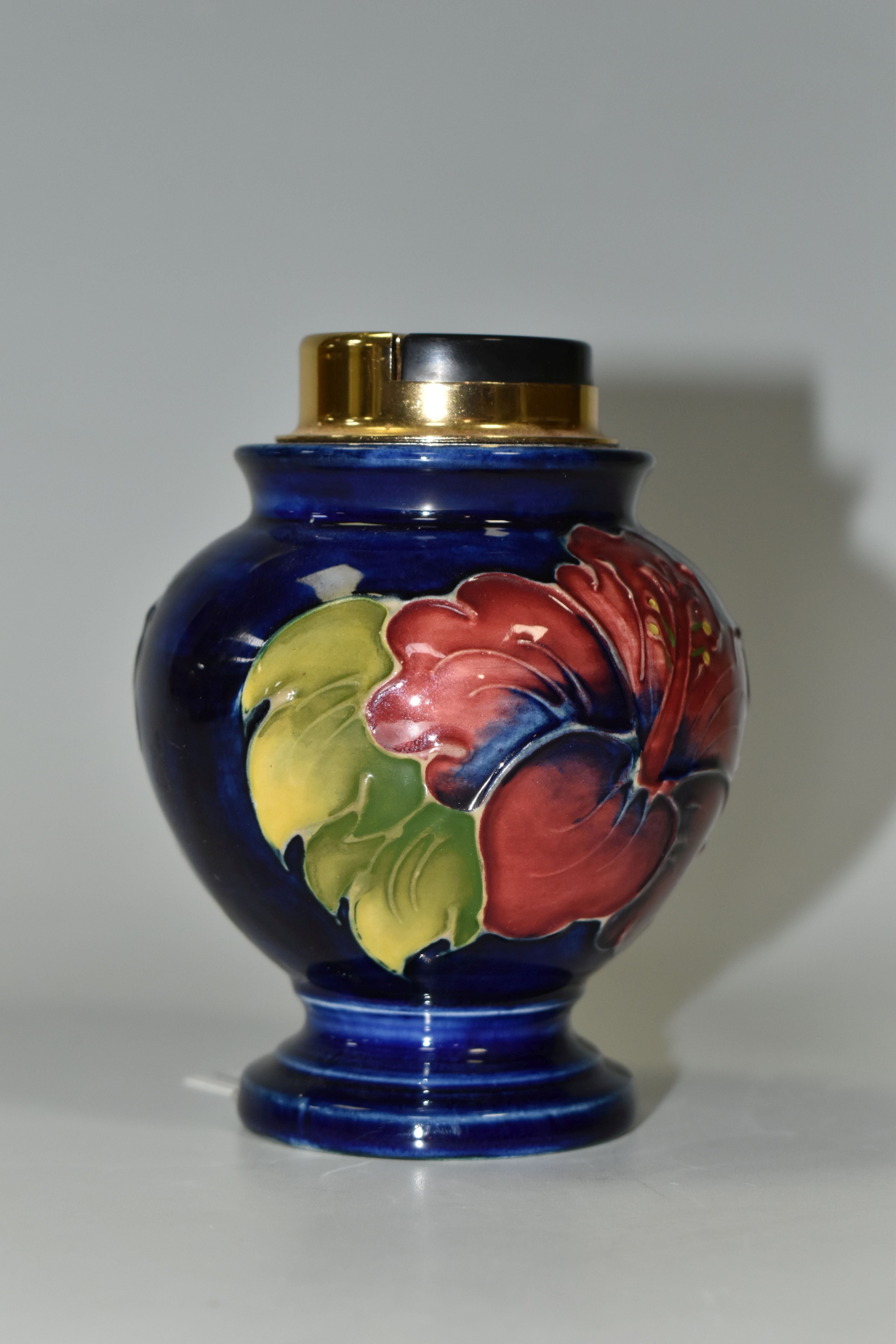 A MOORCROFT TABLE LIGHTER DECORATED WITH DARK PINK HIBISCUS ON A BLUE GROUND, partial remains of a - Image 3 of 5