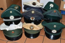 A QUANTITY OF ASSORTED GERMAN POLICE UNIFORM CAPS, with badges, various forces, some with