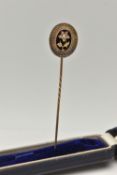 A VICTORIAN CASED STICK PIN, yellow metal unmarked, oval Etruscan pin, decorated with a rose cut