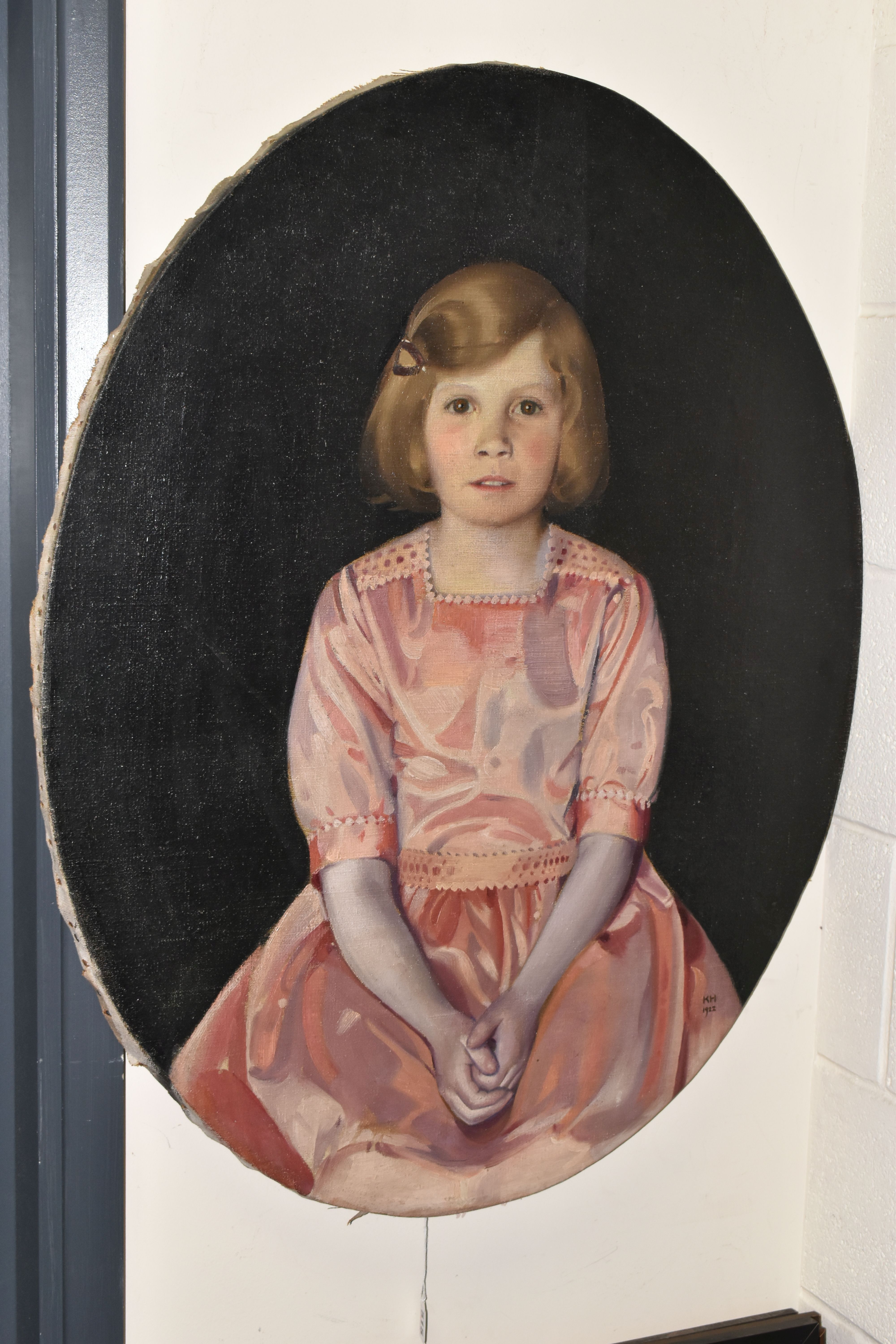 AN EARLY 20TH CENTURY PORTRAIT OF A YOUNG GIRL, the portrait depicts a seated girl wearing a pink