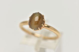 A YELLOW METAL CATS EYE CHRYSOBERYL RING, an oval cats eye chrysoberyl cabochon, approximate