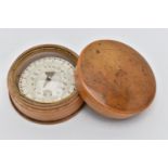 A TREEN POCKET COMPASS, approximate width 54.8mm, instructions label to the base (condition