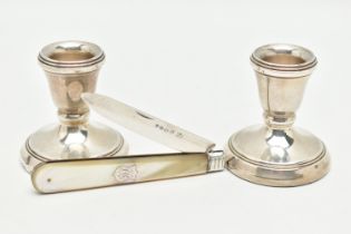 A PAIR OF SILVER DWARF CANDLE STICKS AND A FRUIT KNIFE, polished tapered candle sticks, on round