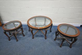 A REPRODUCTION HARDWOOD CIRCULAR COFFEE TABLE, with a bevelled glass insert, raise on six carved