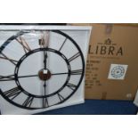 A BOXED 'LIBRA' UNUSED WALL CLOCK, a black and bronze coloured metal wall clock with Roman numerals,