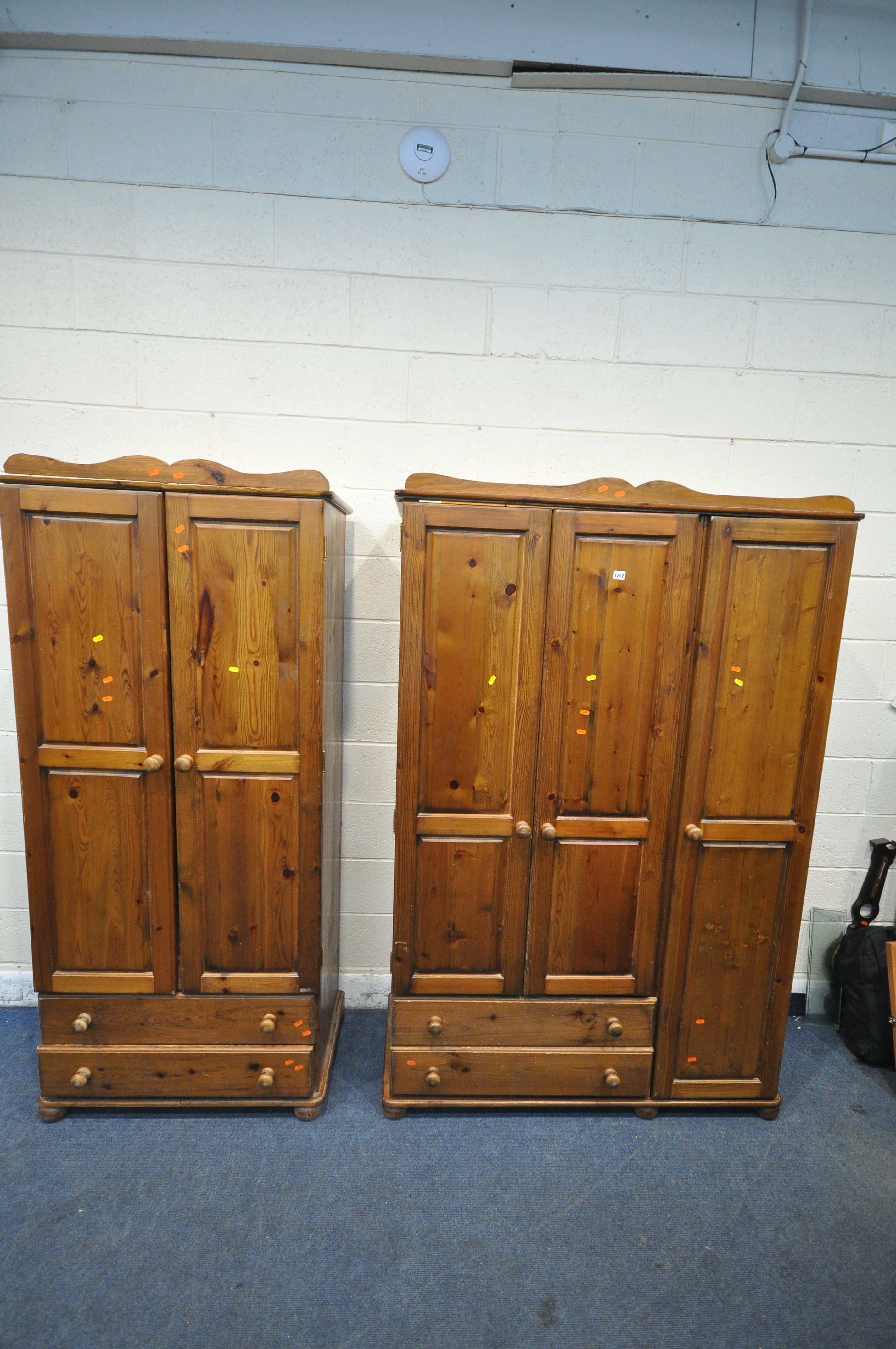 A MODERN PINE TRIPLE DOOR WARDROBE, with two drawers, width 129cm x depth 54cm x height 196cm, along