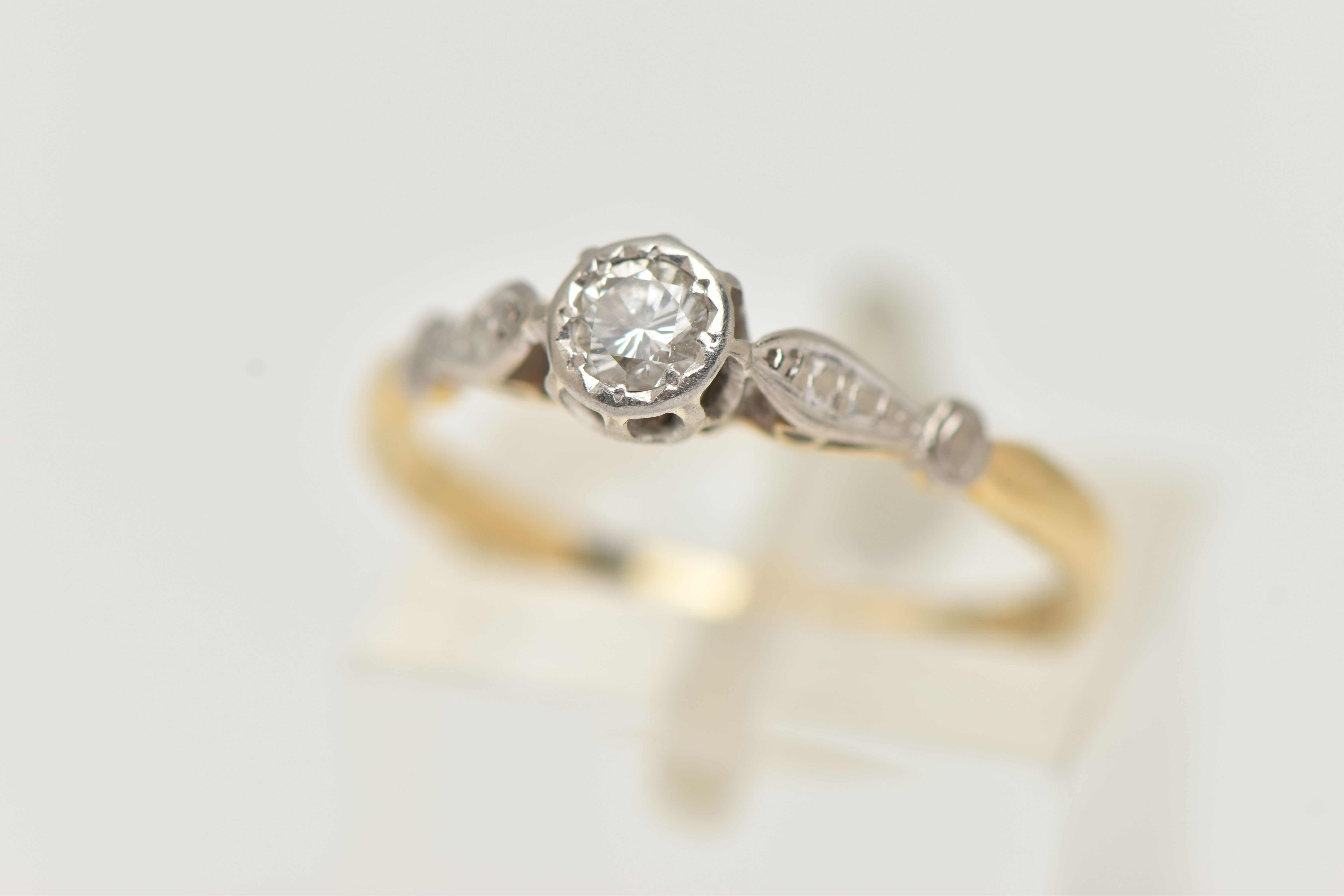 A YELLOW AND WHITE METAL DIAMOND SINGLE STONE RING, illusion set round brilliant cut diamond,