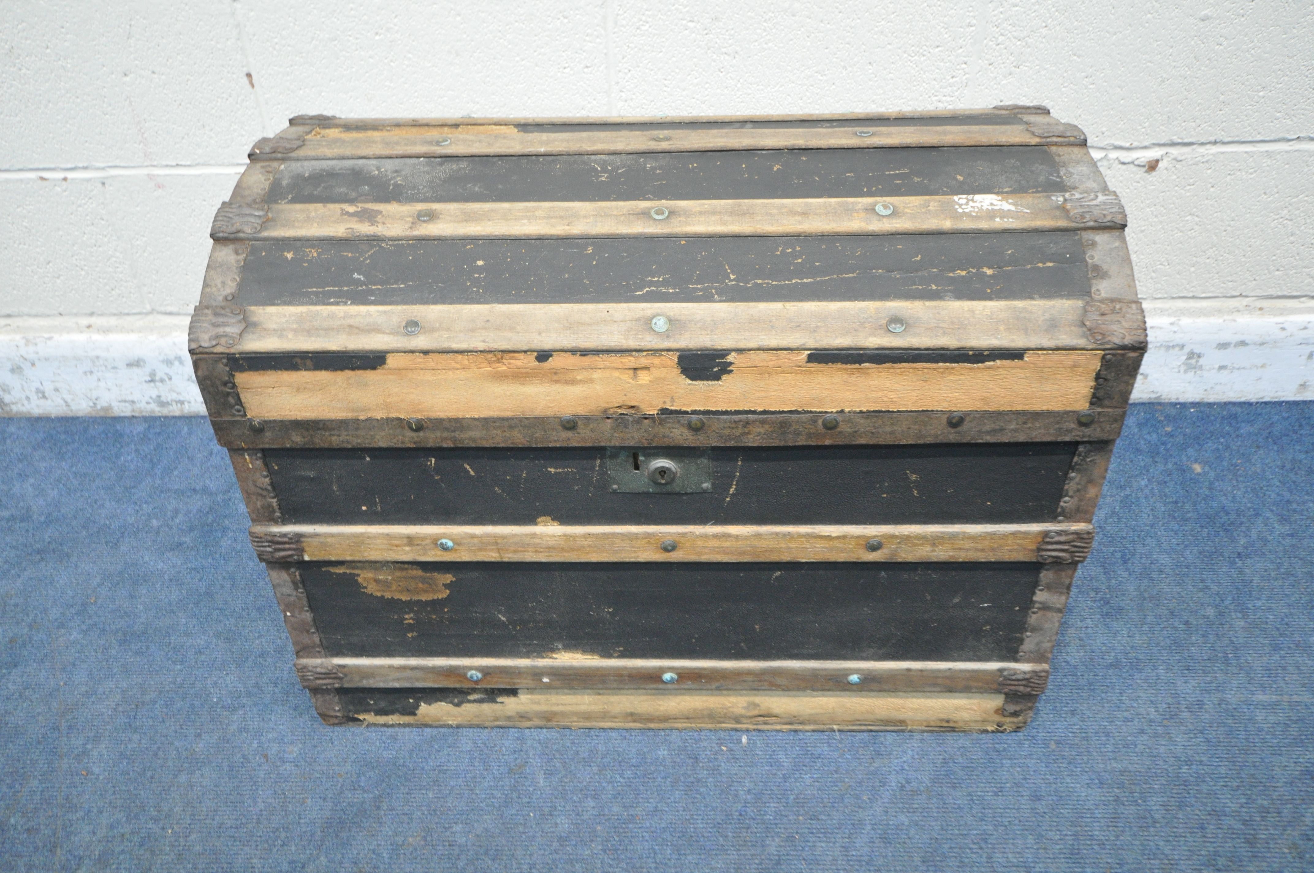 A DOMED TRAVELING TRUNK, with wooden and metal banding, twin handles and a hinged lid, width 77cm