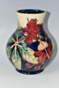 A MOORCROFT POTTERY 'SIMEON' BALUSTER VASE, tubelined with red flowers on a blue and cream ground,