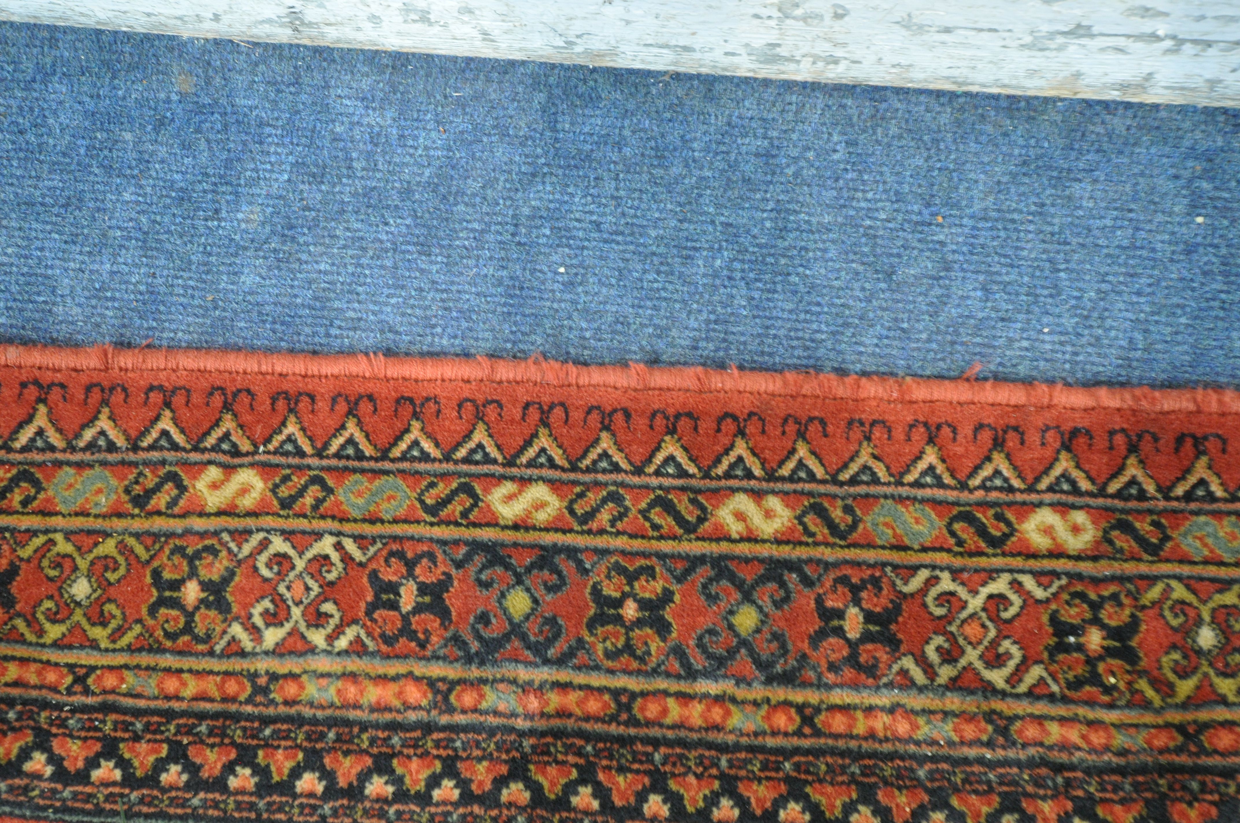 A RED GROUND TABRIZ WOOLLEN RUG, with forty eight central medallions, surrounded by a multi-strap - Image 4 of 5