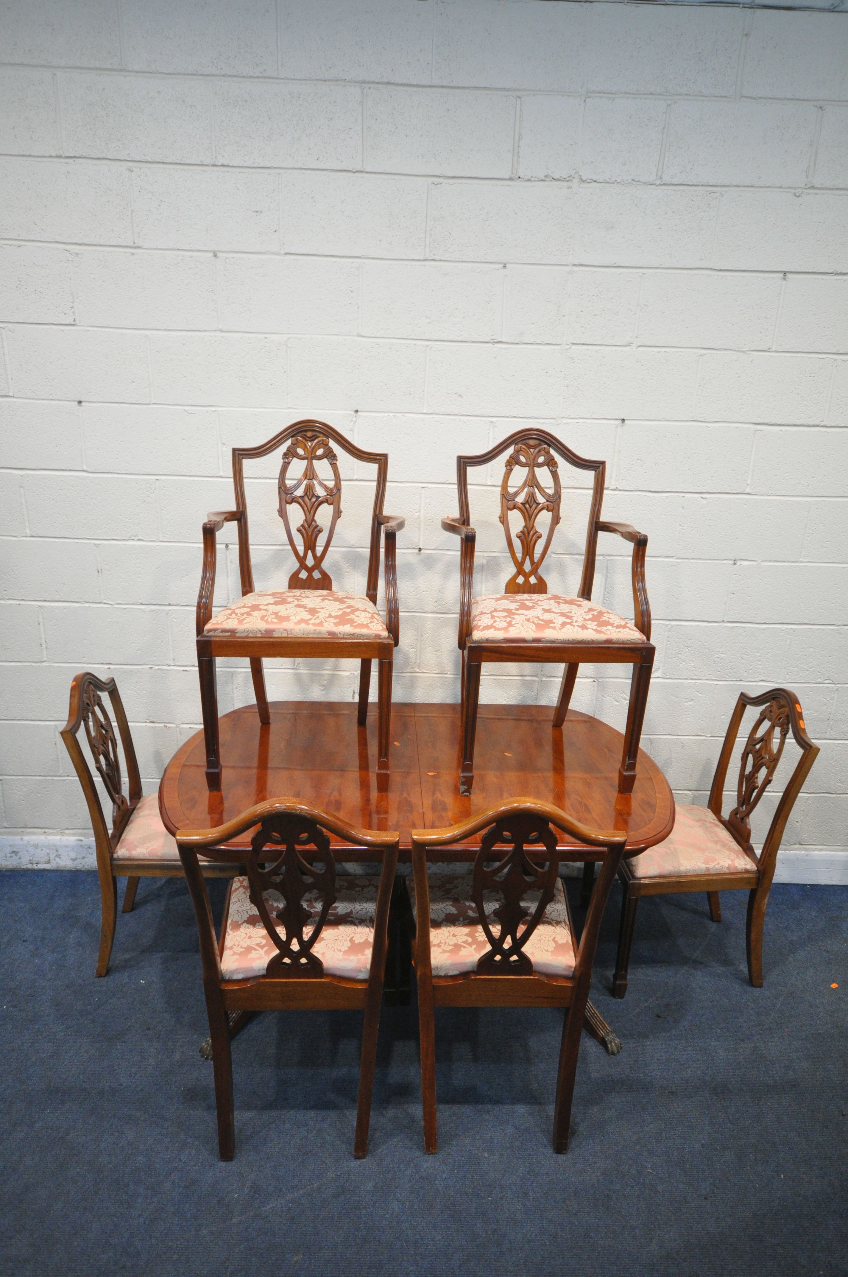 A 20TH CENTURY MAHOGANY OVAL EXTENDING DINING TABLE, with one fold out leaf, length 145cm x depth