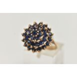 A SAPPHIRE CLUSTER RING, designed as a tiered cluster of circular sapphires in claw settings,