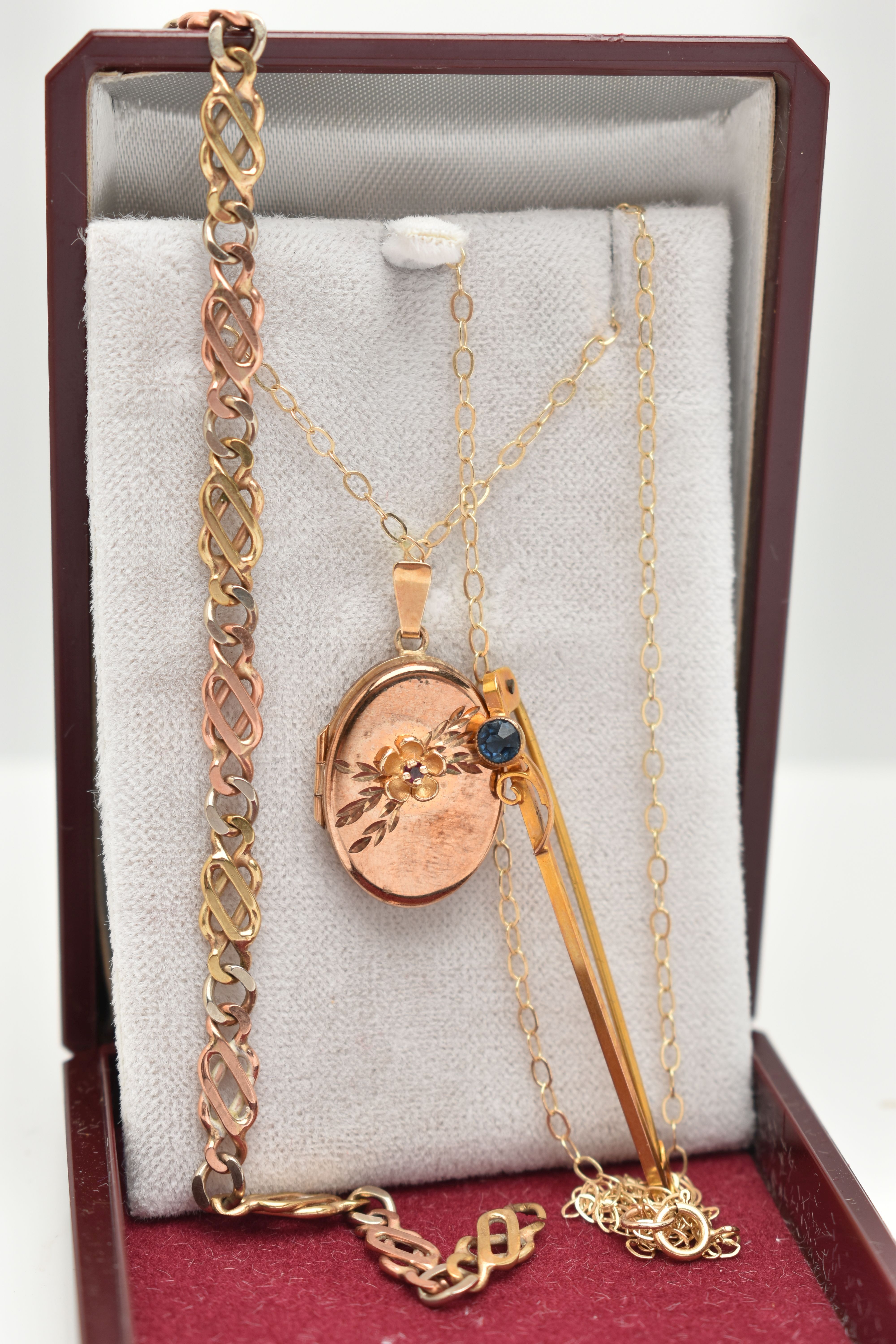 THREE PIECES OF JEWELLERY, to include a 9ct gold oval locket pendant, decorated with a floral