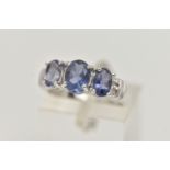 A 9CT WHITE GOLD TANZANITE RING, set with three oval cut tanzanite, each in a four claw setting,