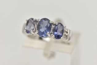 A 9CT WHITE GOLD TANZANITE RING, set with three oval cut tanzanite, each in a four claw setting,