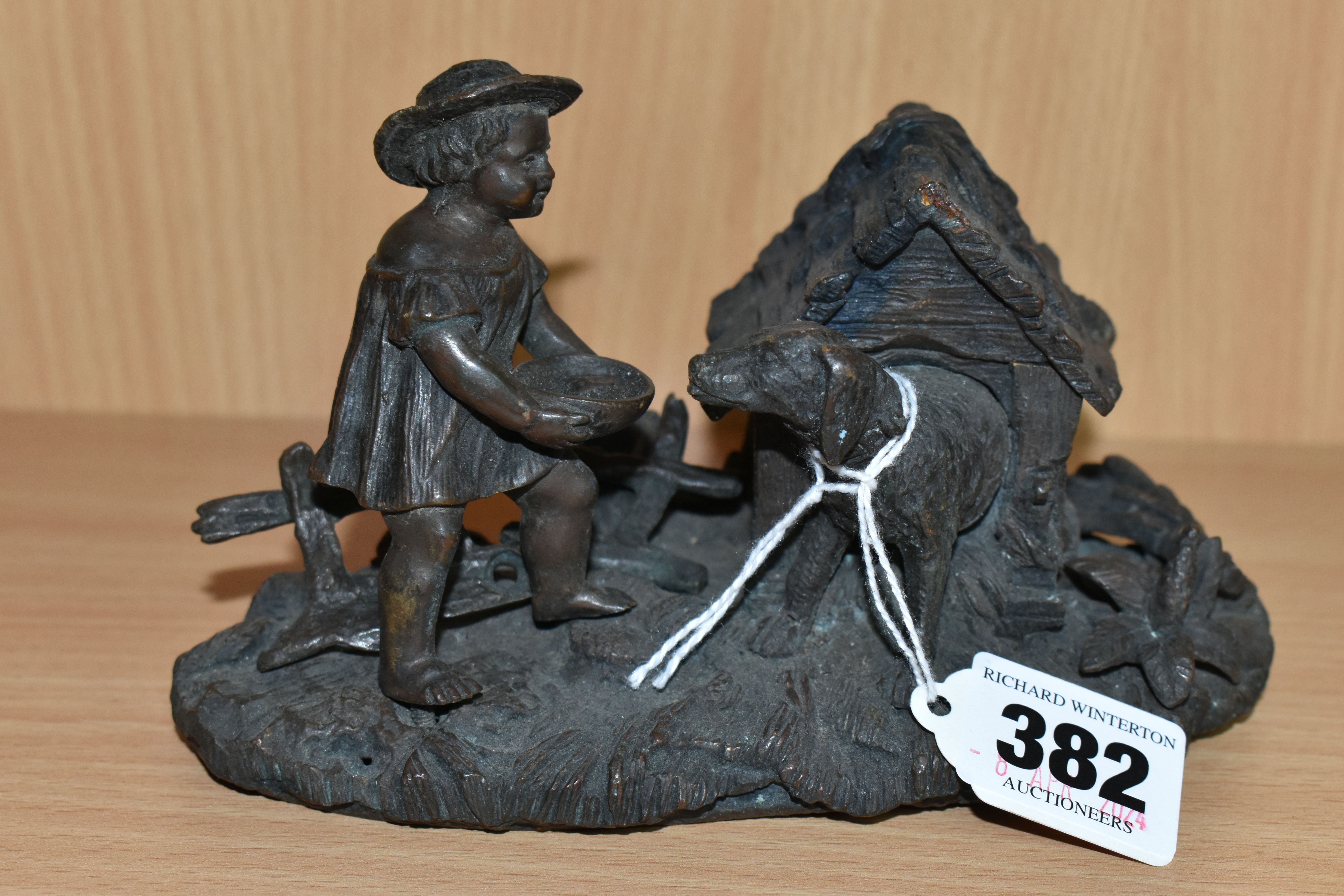 A BRONZE INKWELL, in the form of a dog in a kennel with a small child, unsigned, base width 15.5cm x