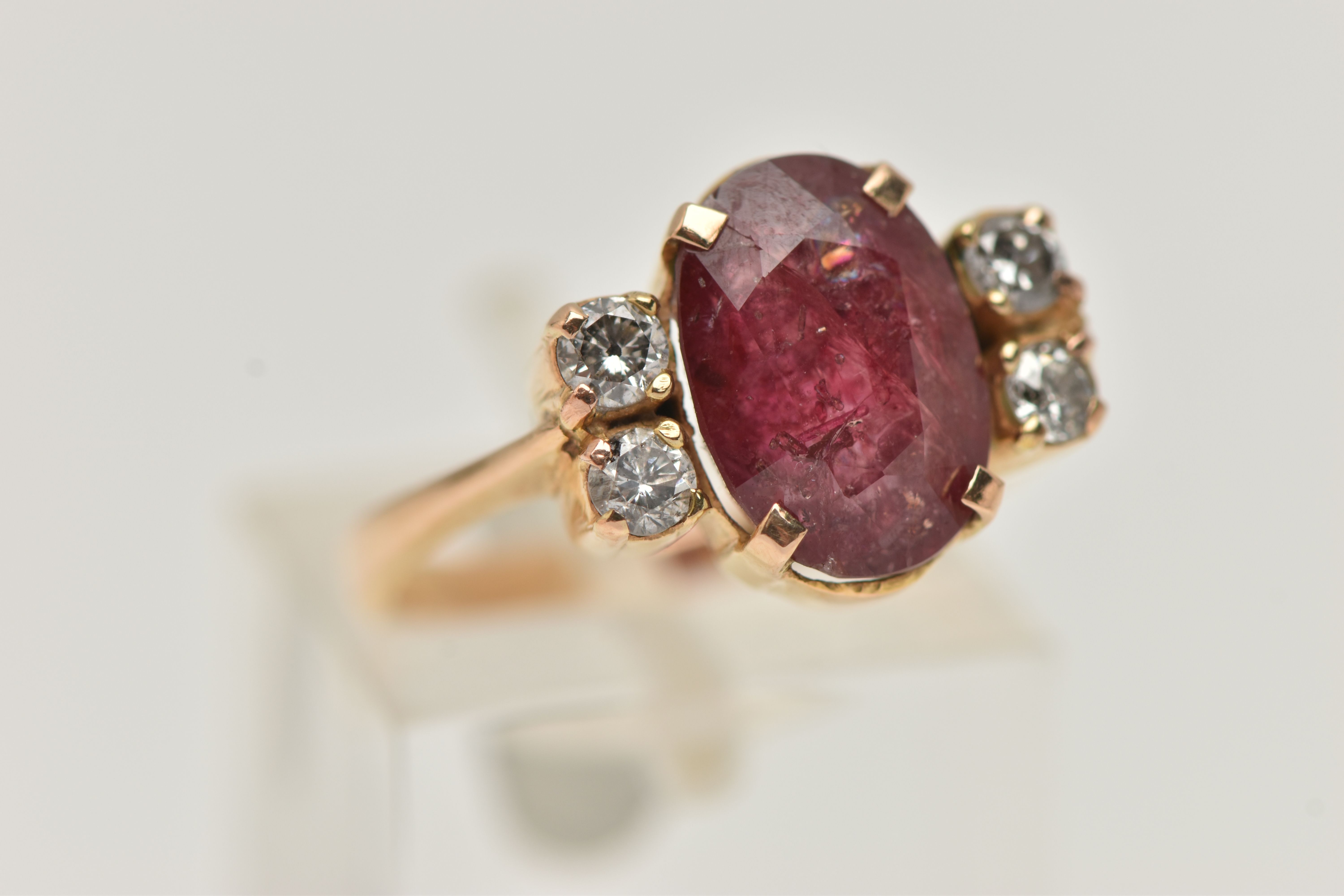 A YELLOW METAL FIVE STONE RING, centering on an oval cut heavily fracture filled red corundum, in - Image 4 of 4