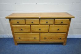 A HEAVY SOLID OAK SIDEBOARD, fitted with an arrangement of nine drawers, length 180cm x depth 51cm x