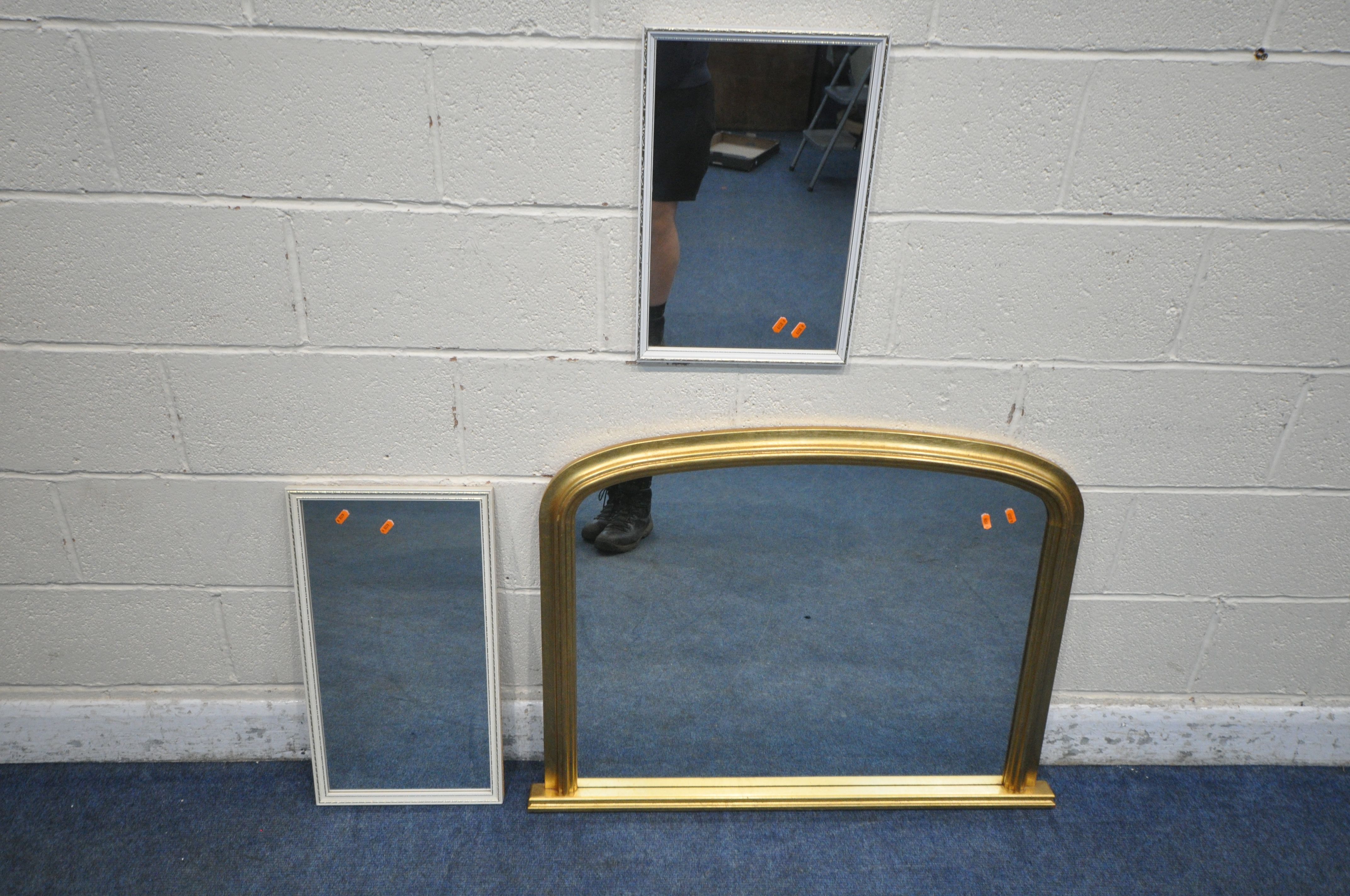 A GILT FRAMED ARCHED OVERMANTEL MIRROR, 98cm x 75cm, along with two small white mirrors (condition