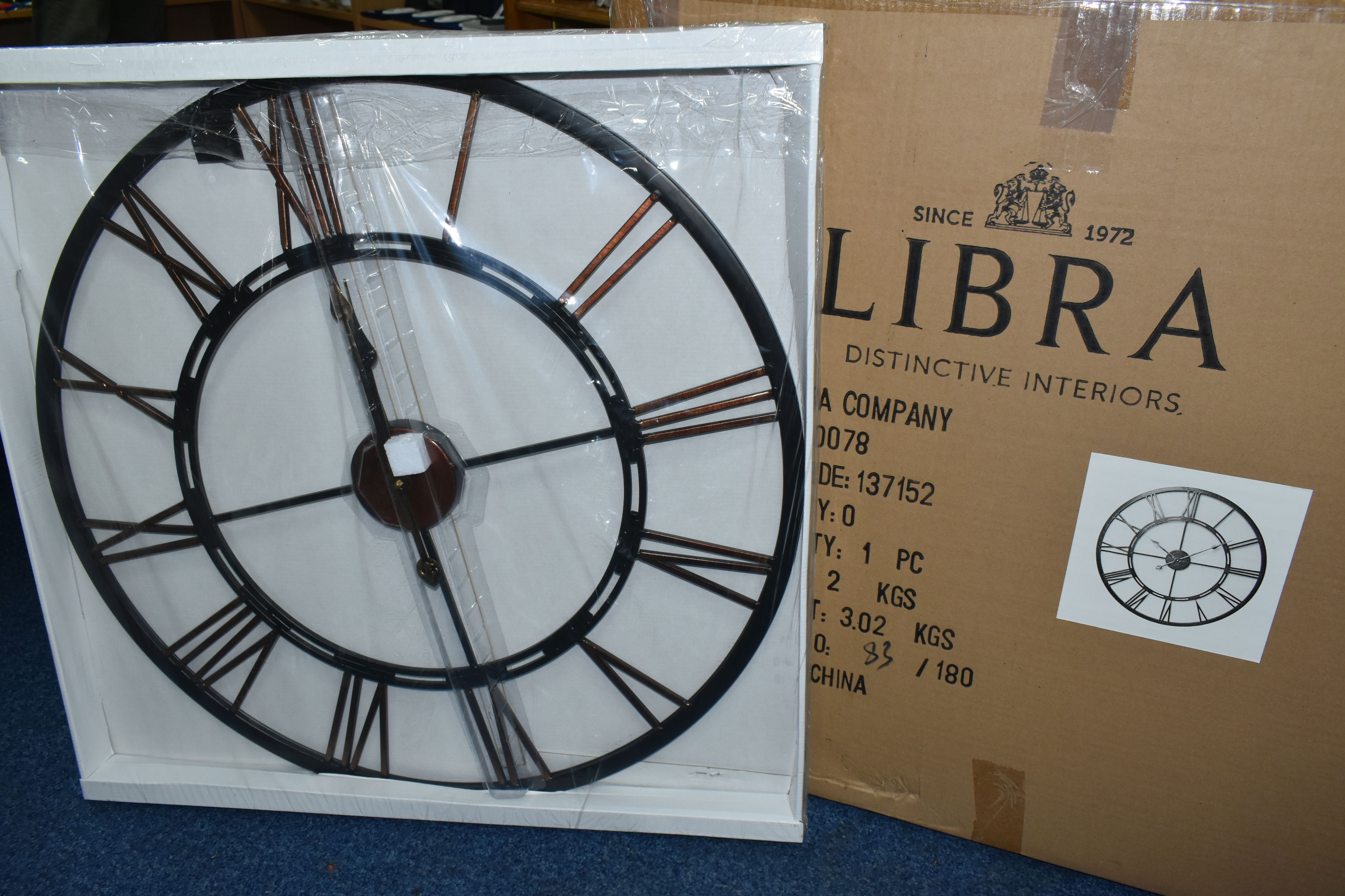 A BOXED 'LIBRA' UNUSED WALL CLOCK, a black and bronze coloured metal wall clock with Roman numerals,