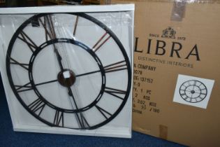 A BOXED 'LIBRA' UNUSED WALL CLOCK, a black and bronze coloured metal wall clock with Roman numerals,