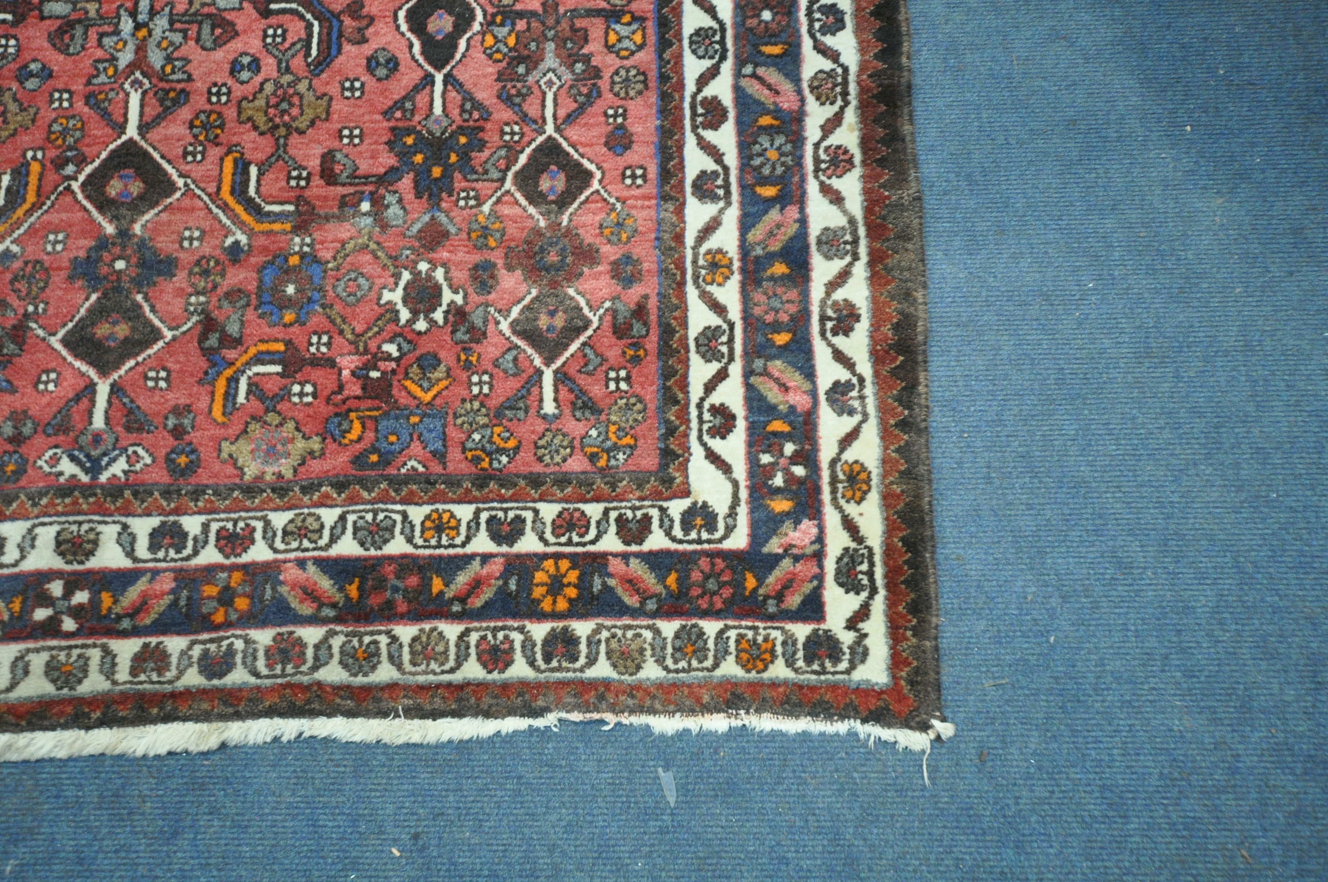 A RED GROUND WOOLLEN RUG, with repeating geometric patterns and multi-strap border, 198cm x 194cm ( - Image 2 of 3