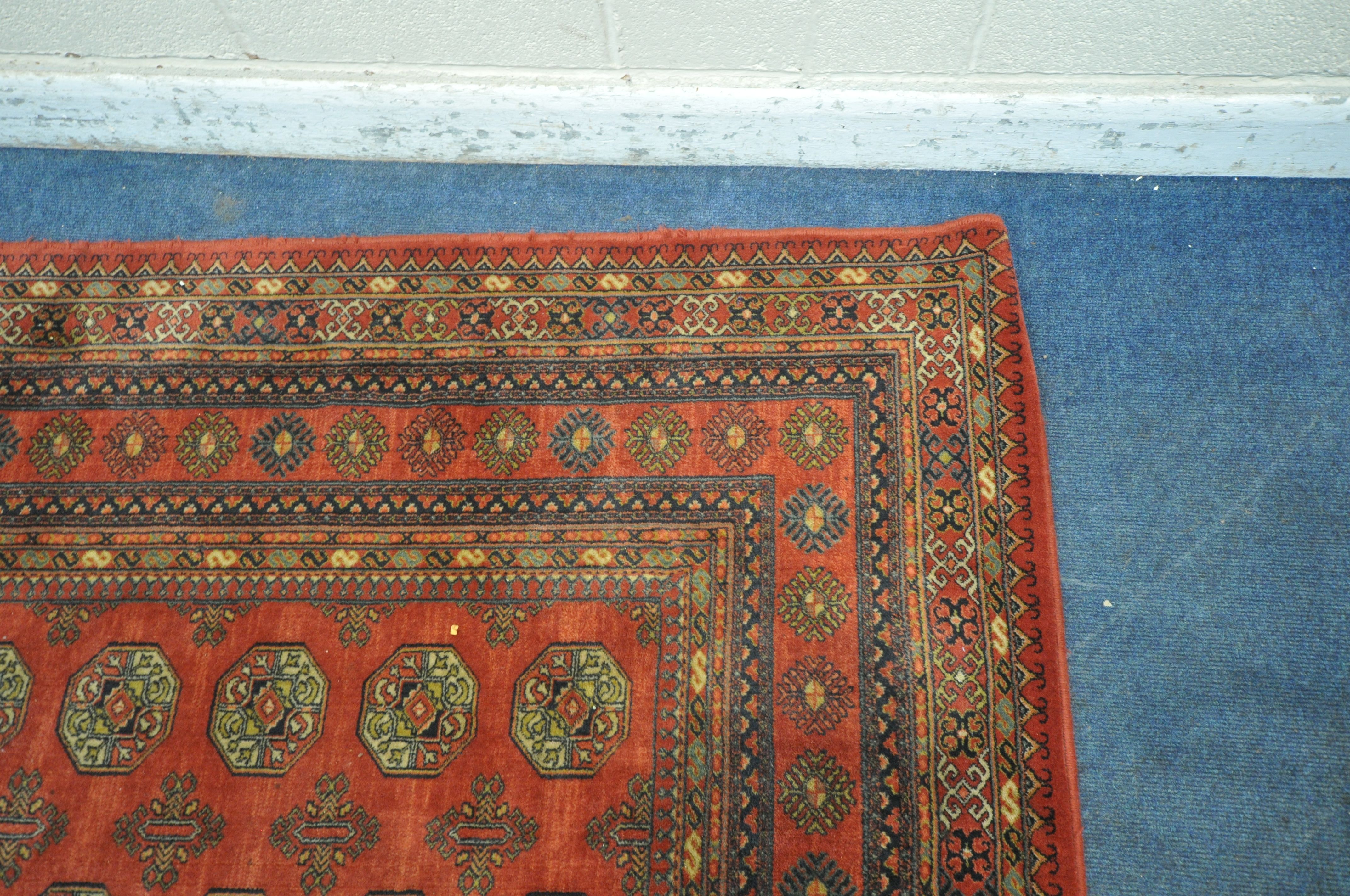 A RED GROUND TABRIZ WOOLLEN RUG, with forty eight central medallions, surrounded by a multi-strap - Image 3 of 5