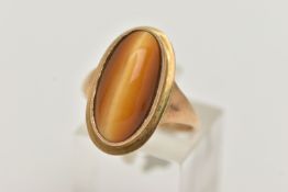 A 9CT GOLD DRESS RING, an elongated oval cabochon tigers eye, collet set in yellow gold, leading