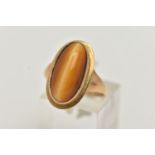 A 9CT GOLD DRESS RING, an elongated oval cabochon tigers eye, collet set in yellow gold, leading