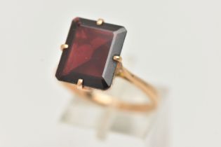 A GARNET DRESS RING, a large rectangular cut garnet, approximate length 13mm x width 11mm, four