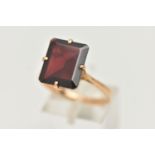 A GARNET DRESS RING, a large rectangular cut garnet, approximate length 13mm x width 11mm, four